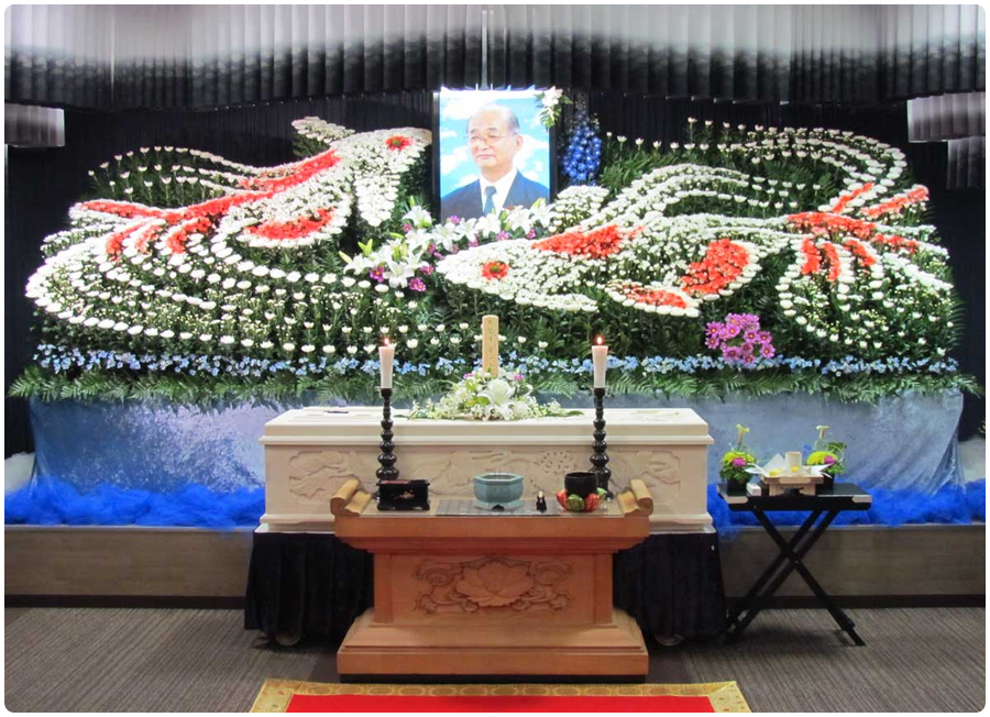 2014年10月11日、有限会社 小田原市民葬祭の創設者 望月守一が、満77歳にて死去致しました。生前 皆様に大変お世話になりました事、ここに謹んで御礼を申し上げます。誠にありがとうございました。望月会長はとにかく命を大切にする方で、植物や生き物のお世話が上手な方でした。祭壇に飾らせて頂きましたのは、2匹の金魚。私共の事務所にお越し頂いた方はご存知かと思いますが、縁日で掬い上げてきた金魚が 今では5代にも続く大家族になり、道行く子供達の人気者。我社のマスコット的な存在となっております。望月会長を2匹の金魚が天国まで導くイメージを、最期のお別れに送りました。社の礎を築き、歩むべき道をその背中で示してくれた望月会長へ敬意を表し、その意思を受け継ぐべくより一層励んで参ります。皆様大変お世話になり誠にありがとうございました。